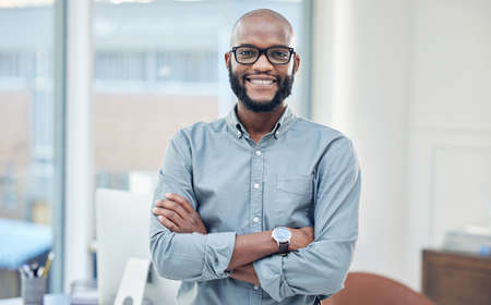 Its a good day to be successful. Shot of a handsome young businessman standing alone in his office...