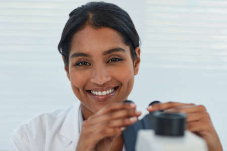 The answers are all in the details. Portrait of a young female scientist working in a lab.
