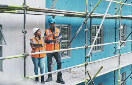 Shaping the future of construction with the help of smart apps. Shot of a young man and woman using...