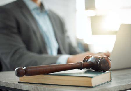 Wielding the hammer of justice. Shot of a lawyer working on his laptop.