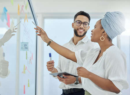 Theyre at the top of their game. Cropped shot of two diverse young businesspeople working on a glass...