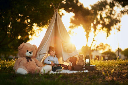 All he needs is a little imagination. Portrait of a cute little boy playing in his teepee outside.の写真素材