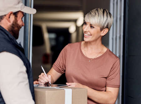 Ill be sure to make use of your express delivery again. Shot of a young woman signing for a delivery...