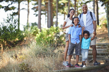 We all love a good walk in the forest. Portrait of an african american family enjoying a day out in the forest.の写真素材