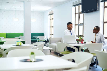 They stay productive throughout the day. Shot of two businessmen having a discussion in an office.