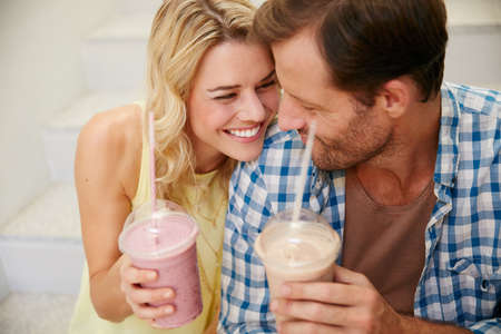 I just cant get enoughand the smoothies great too. Shot of a happy couple enjoying refreshing shakes together.の写真素材