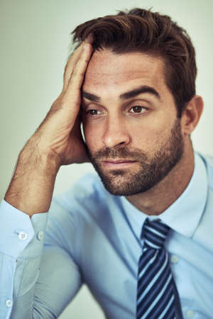 Weary from work. Shot of a tired looking young corporate businessman.の写真素材
