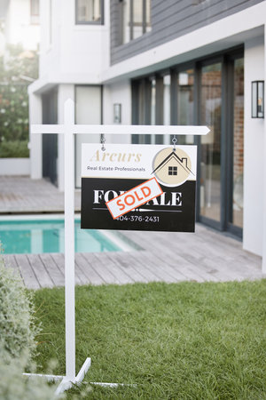 Home is the nicest word there is. Shot of for sale sign with a sold sticker outside a house.の写真素材