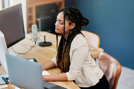 Working hard to get her company off the ground. High angle shot of an attractive young woman working...