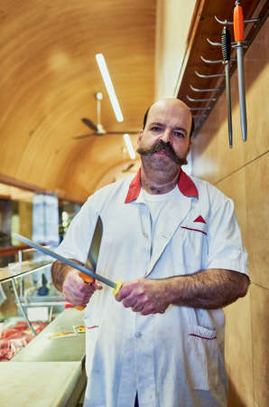 I always make sure my knives are sharp enough. Shot of a butcher at his store.の写真素材