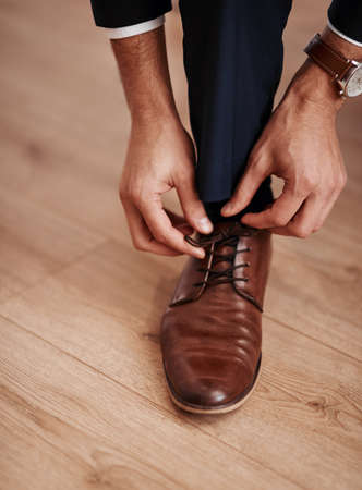 Im ready for the next step in my life. Cropped shot of an unrecognizable man putting on his shoes.の写真素材