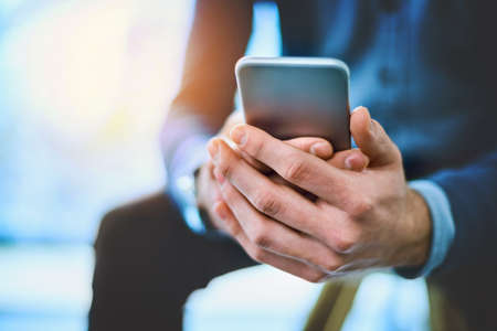 Hes always on work mode. Shot of an unrecognizable businessman using his cellphone at work.
