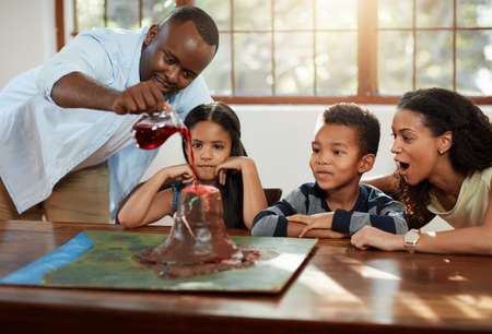 Time to test this thing out. Cropped shot of a young couple helping their kids with a school project.の写真素材