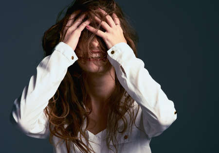 Messy hair dont care. Studio shot of an unrecognizable woman covering her face with her hair against...