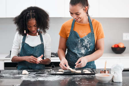 Baking is our favourite hobby. Shot of a mother and daughter baking together in the kitchen at home.