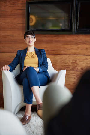 Shes boss of this boardroom. Full length shot of a businesswoman sitting in the boardroom.の写真素材