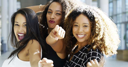 We do business our own way. Cropped shot of three attractive young businesswomen dancing happily in the workplace.の写真素材