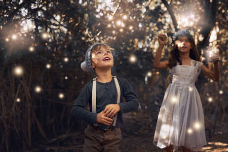 The fireflies have come out to play. Shot of two little siblings catching fireflies in jars outside.の写真素材