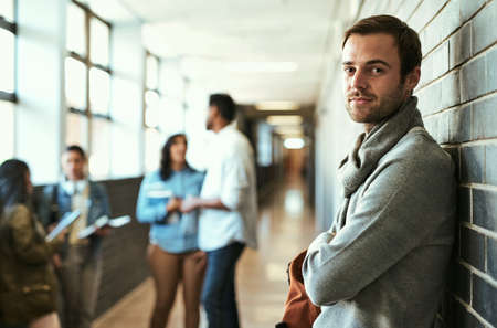 Campus life suits me. Cropped portrait of a handsome male university student standing with his arms...