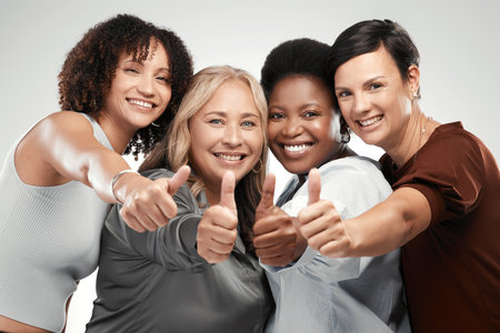 Nothing but good vibes here. Shot of a diverse group of women standing together in the studio and showing a thumbs up.の写真素材