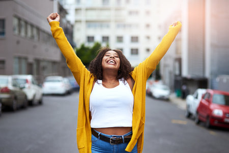 Feels great to be young and alive. Cropped shot of a happy young woman celebrating with arms raised...