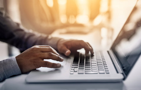 Working hard to increase efficiency and gain a competitive advantage. Closeup shot of an unidentifiable businessman working on a laptop in an office.の写真素材