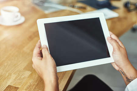 All the right tools at your disposal. Closeup shot of a person holding a digital tablet in a modern...