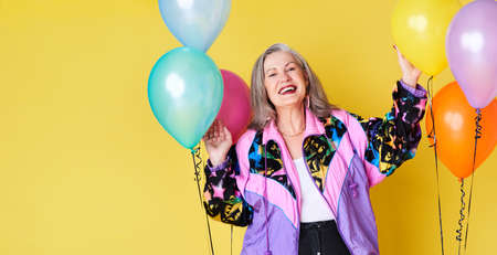 Lets get this party jumping. Portrait of a cheerful and stylish senior woman posing with balloons...