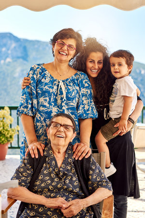 Four generations living together. Portrait of a cheerful family standing and holding each other...