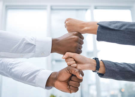 Im confident that well succeed. Shot of two businesspeople stacking their fists on top of each...