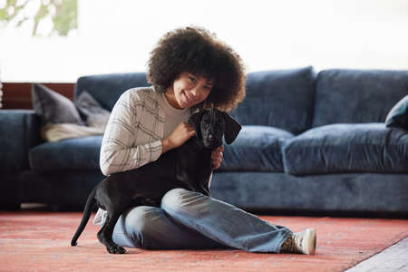 Every dog must have his day. Shot of a young woman playing with her dog at home.の写真素材