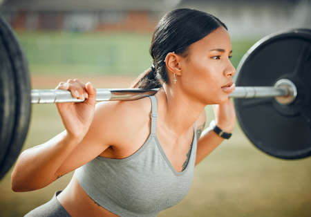 Lifting her spirits. Cropped shot of an attractive young female athlete exercising with weights outdoors.の写真素材