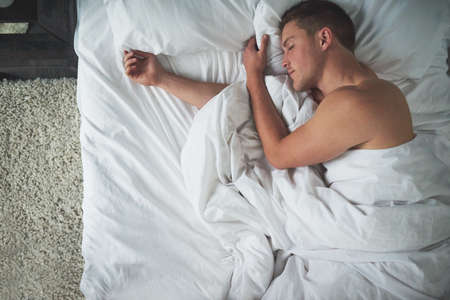 The pleasure of sleep. Cropped shot of a shirtless young man sleeping in his bedroom.