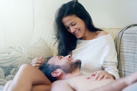 To be young and in love. Shot of a young couple enjoying a romantic moment on the sofa together in...