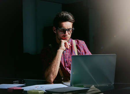 He puts a lot of thought into his designs. Cropped shot of a handsome young designer working on his...