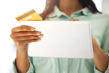 Need to make some quick payments. Cropped shot of an unrecognizable person using a credit card and a...