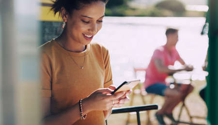 Im so happy he finally messaged me. Shot of a young woman smiling as she uses her smartphone.