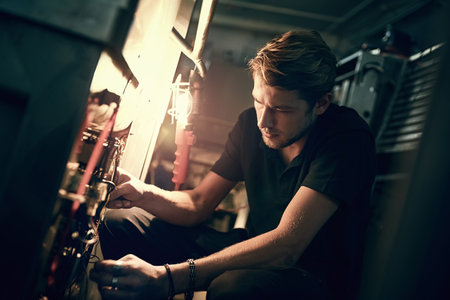 Making the necessary adjustments. Cropped shot of a handsome young man making some repairs indoors.