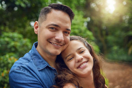 Sharing one of lifes precious gifts. Cropped portrait of a happy father spending time with his daughter at the park.の写真素材