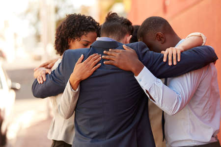 We draw support and motivation from each other. Shot of a group of businesspeople standing together in a huddle outdoors.の写真素材