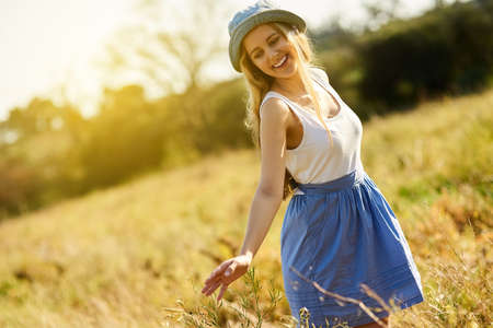 Quiet people have the loudest minds. Shot of a young woman on a tree stump out in the countryside.の写真素材