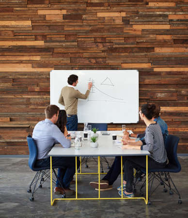 This is where we have to focus on. Shot of a group of coworkers sitting at a conference table during...
