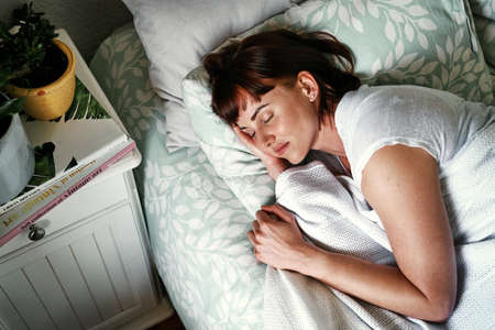 Shes stuck in la la land. High angle shot of an attractive young woman sleeping in her bed at home.