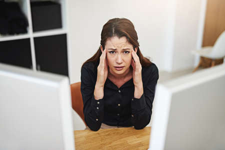 I dont want to be here. Portrait of a young businesswoman looking stressed out at her desk.