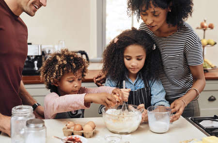 What makes it delicious is the love you put in. Cropped shot of a young couple baking at home with...
