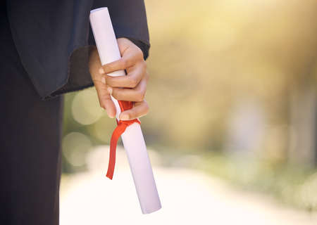 You deserve to get that degree. Shot of an unrecognisable woman holding a certificate on graduation day.の写真素材