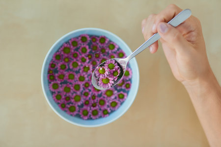 Its a culinary and visual feast. High angle shot of an unrecognizable man eating a bowl full of pretty pink flowers.の写真素材