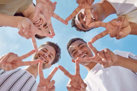 You shine brighter than a star. Shot of a group of young friends making a star shape with their hands outside.の写真素材