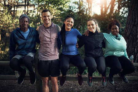We all friends just trying to get fit. Portrait of a group of sporty young friends working out in...