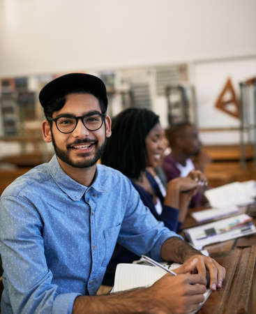 Hes happy about the task they received. Portrait of an university student sitting in class.